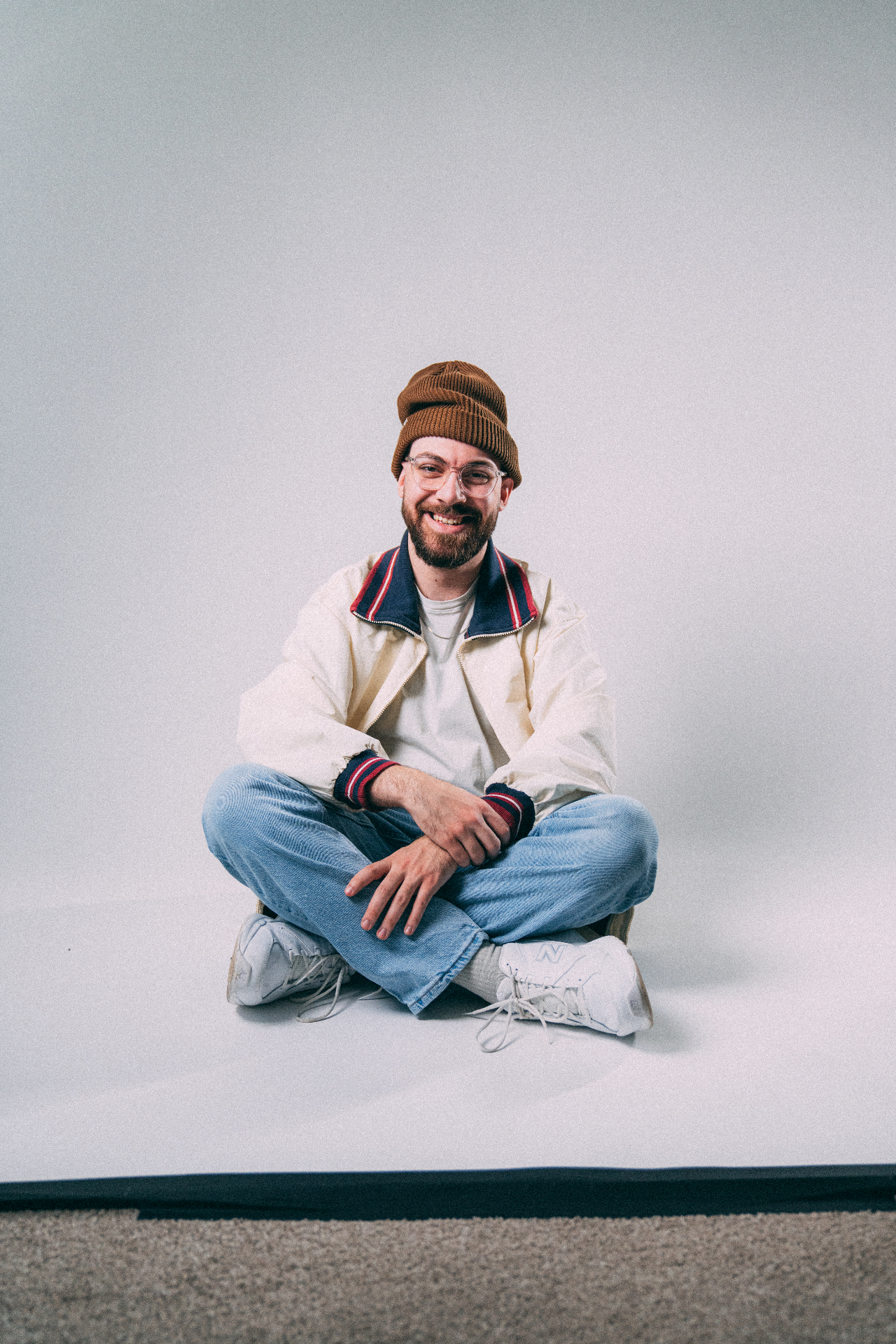 Christian sitting cross-legged in studio with beanie