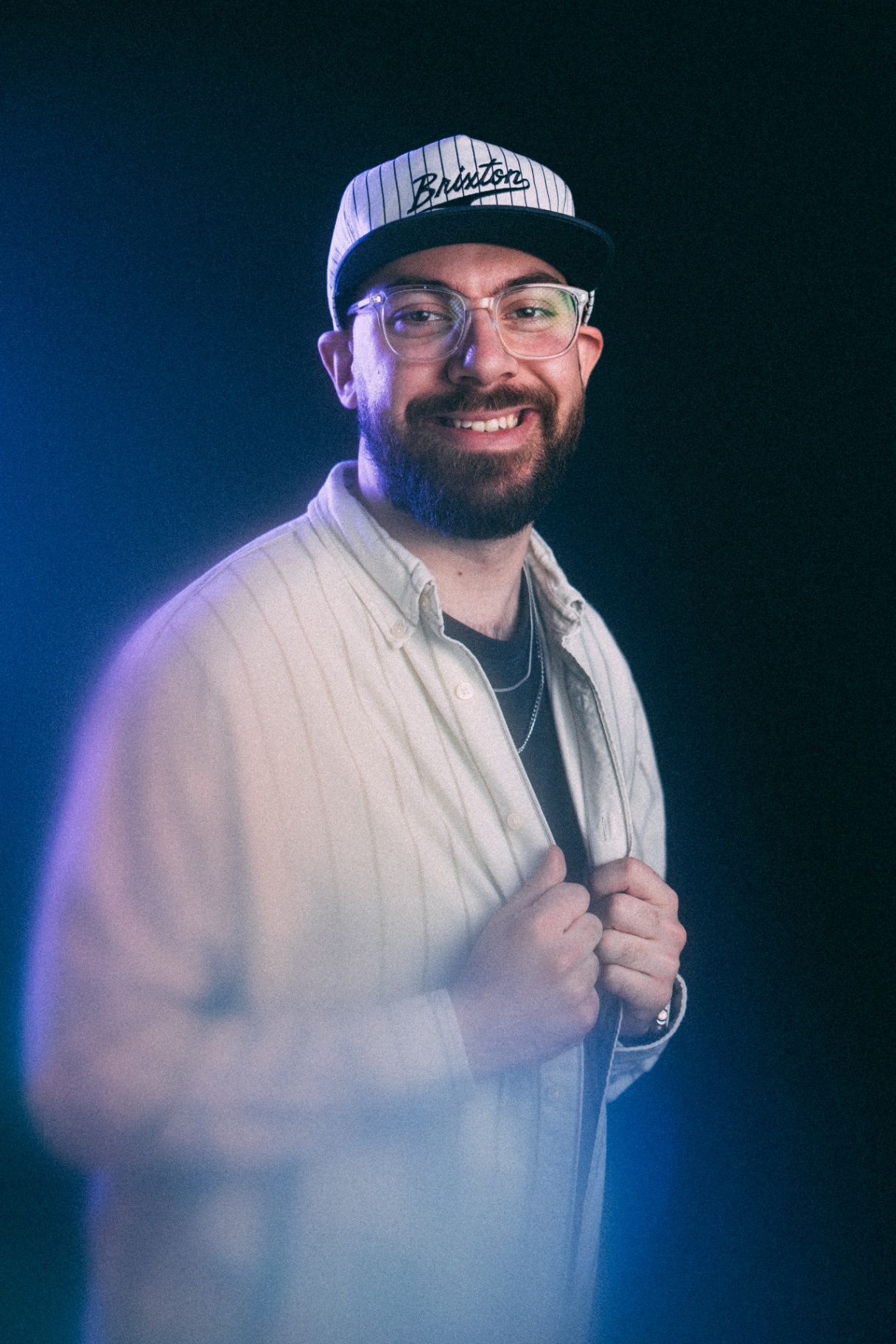 Christian smiling in a white striped shirt and cap